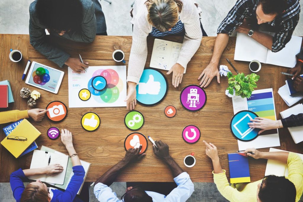 Table of people with different colorful icons spread out