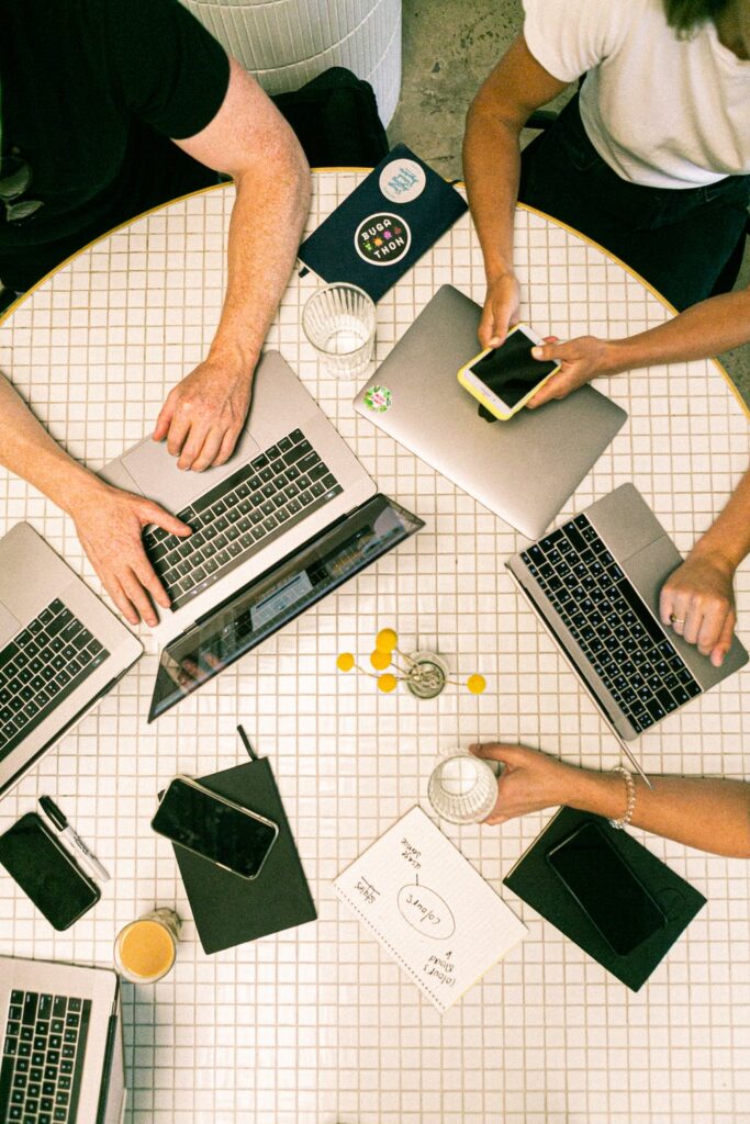 A group of people sitting at a table with a computer

Description automatically generated